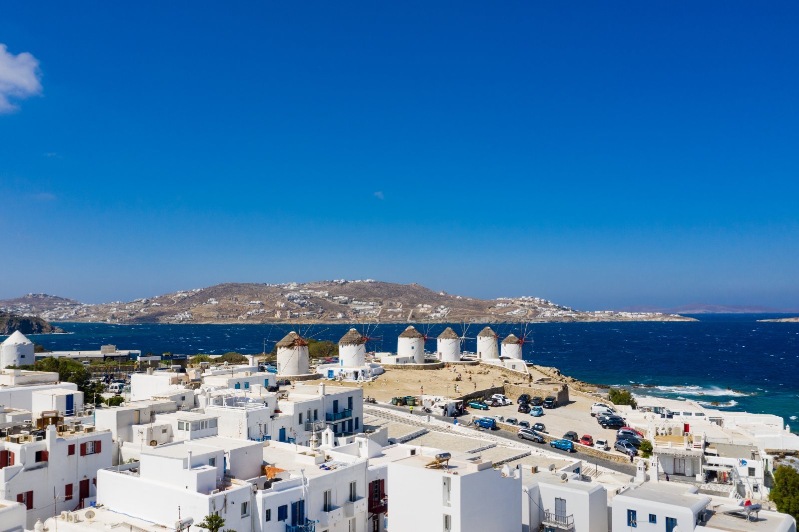 Traditional white windmills overlooking Mykonos Town at golden hour