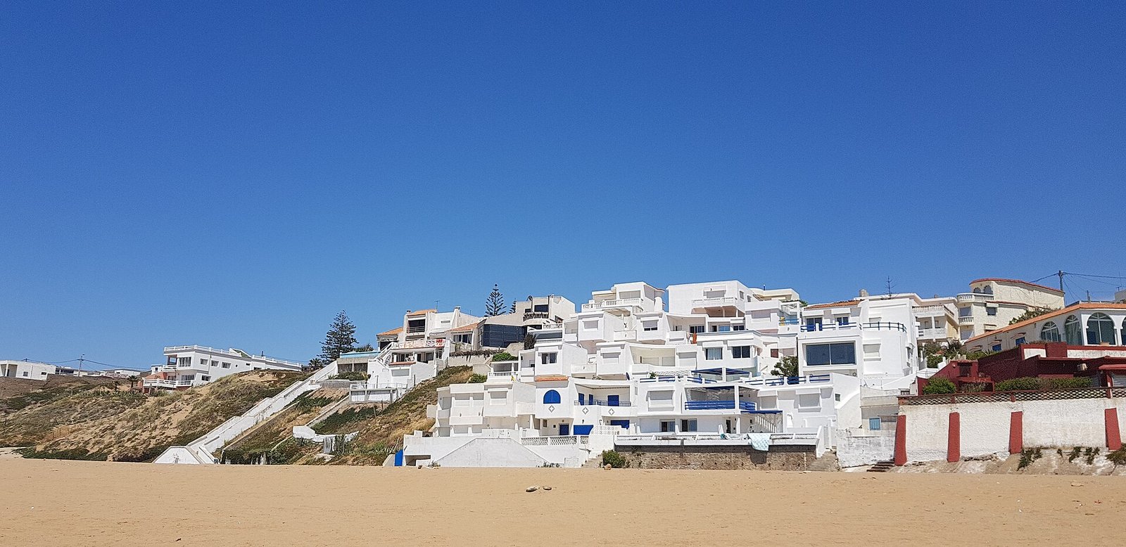 Stunning view of a structue just beside the beach, inspired by a Greek island in Santorini. — Photo: Elwyn Lloyd, CC BY-SA 4.0, via Wikimedia Commons