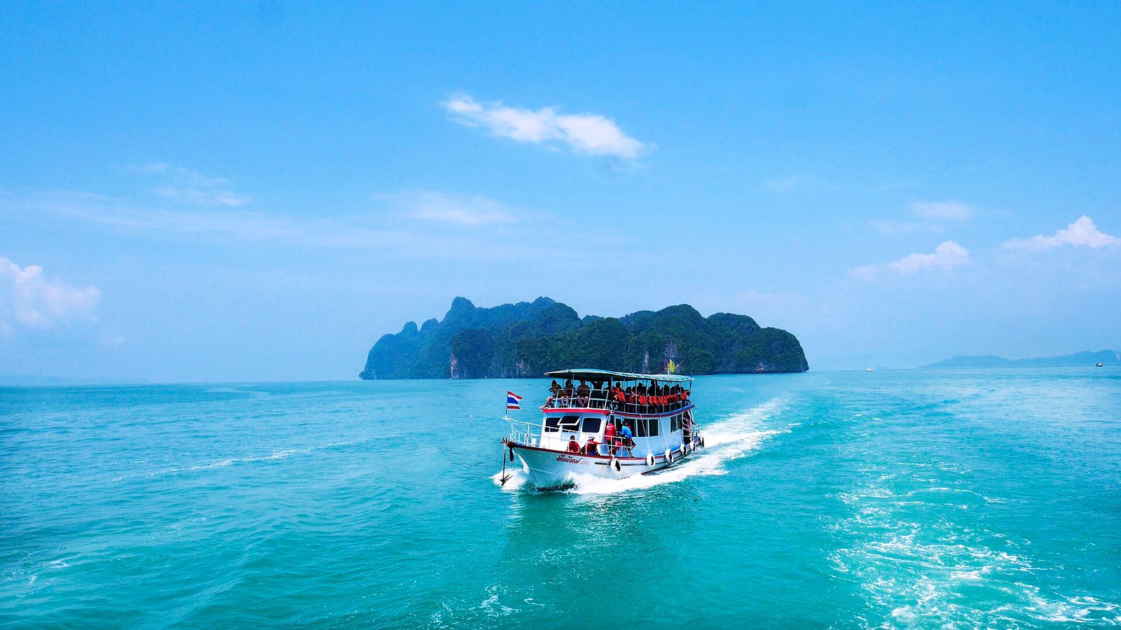 Boat cruising among limestone karsts in Phang Nga Bay near Phuket, Thailand